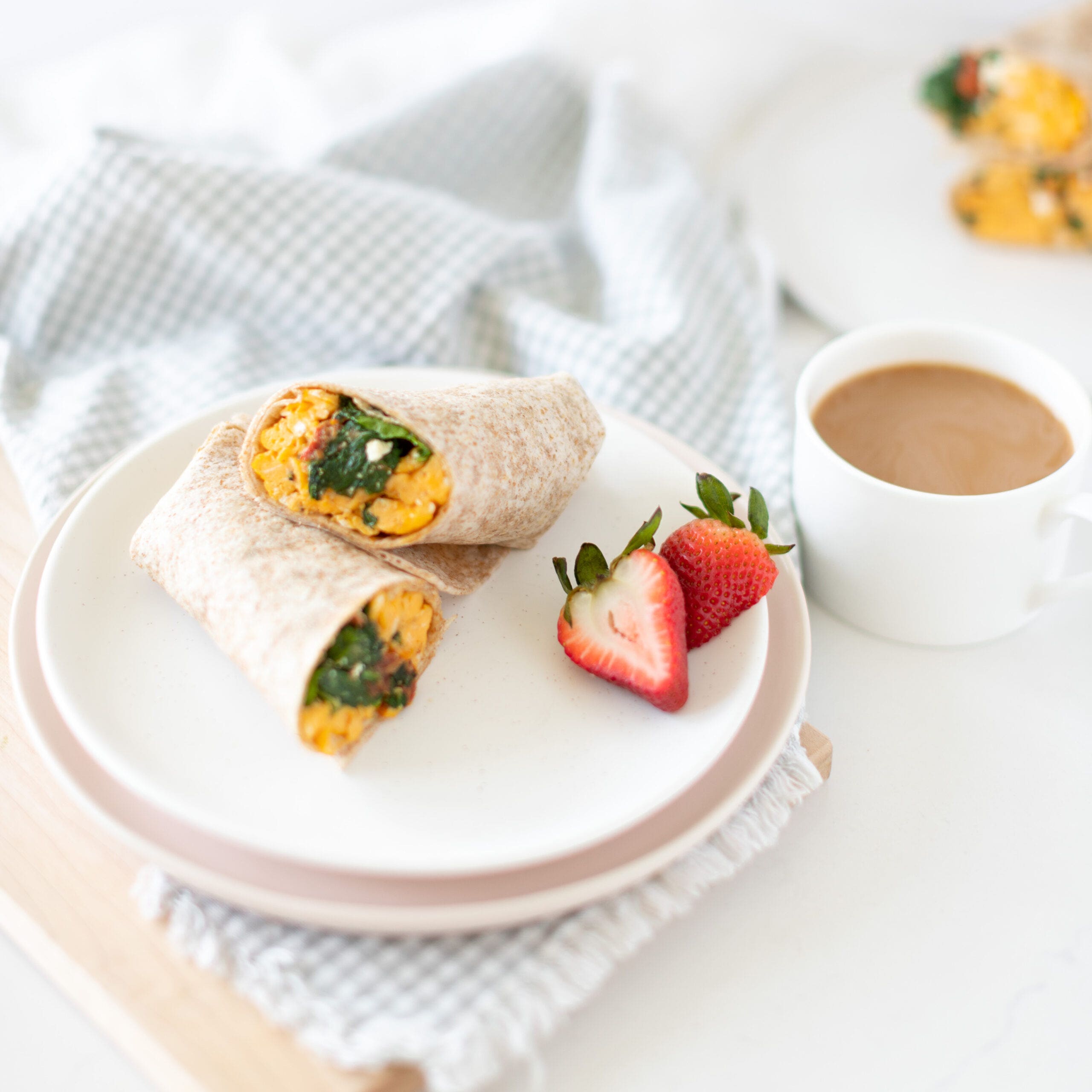 overhead shot of spinach and feta wrap with egg and strawberries