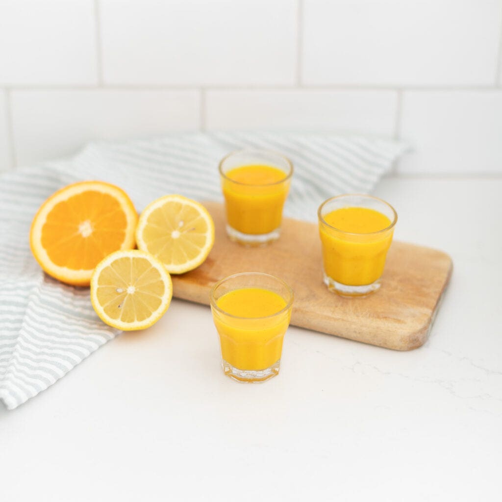 yellow turmeric and ginger wellness shots in small glasses