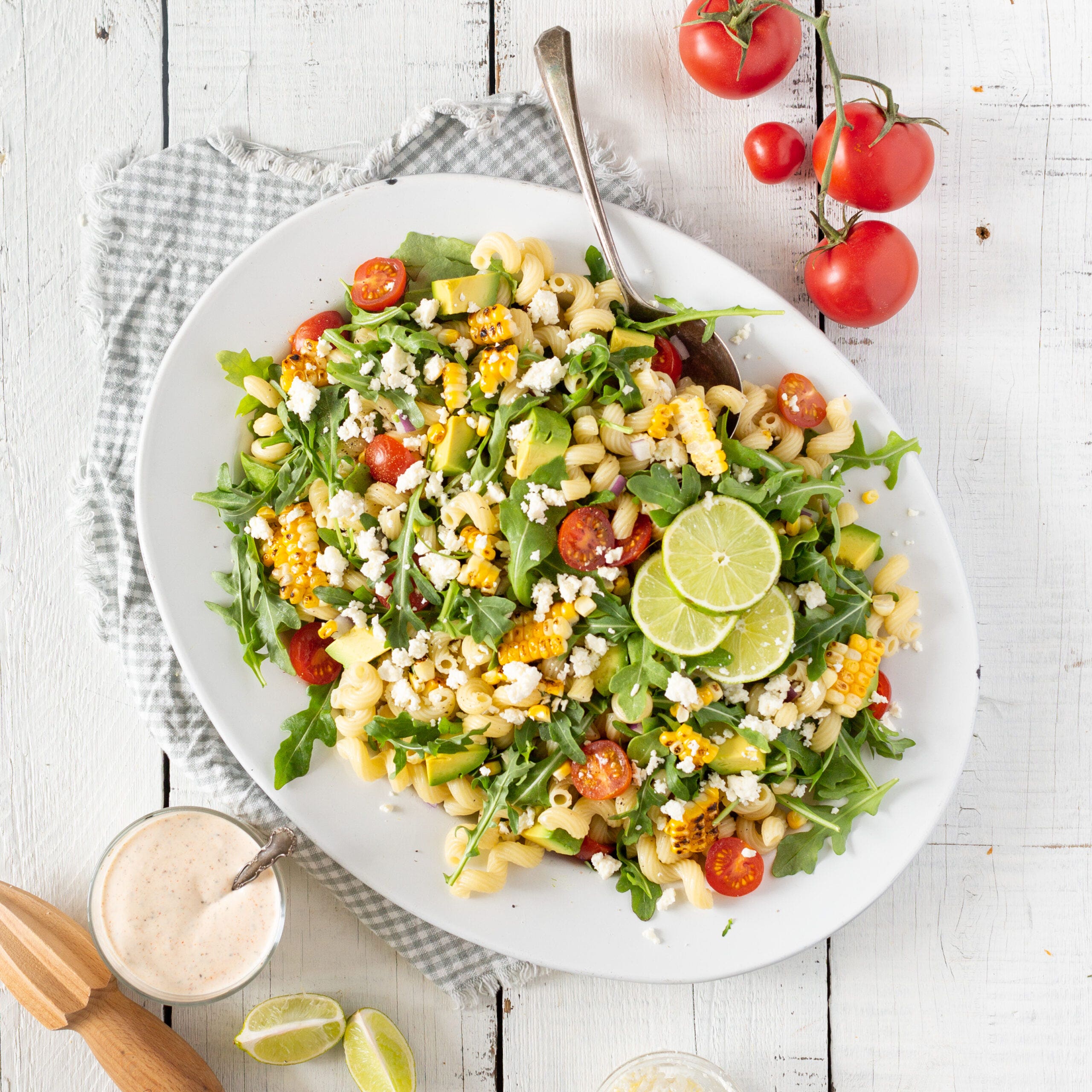 grilled corn pasta salad on a serving plate with sauce