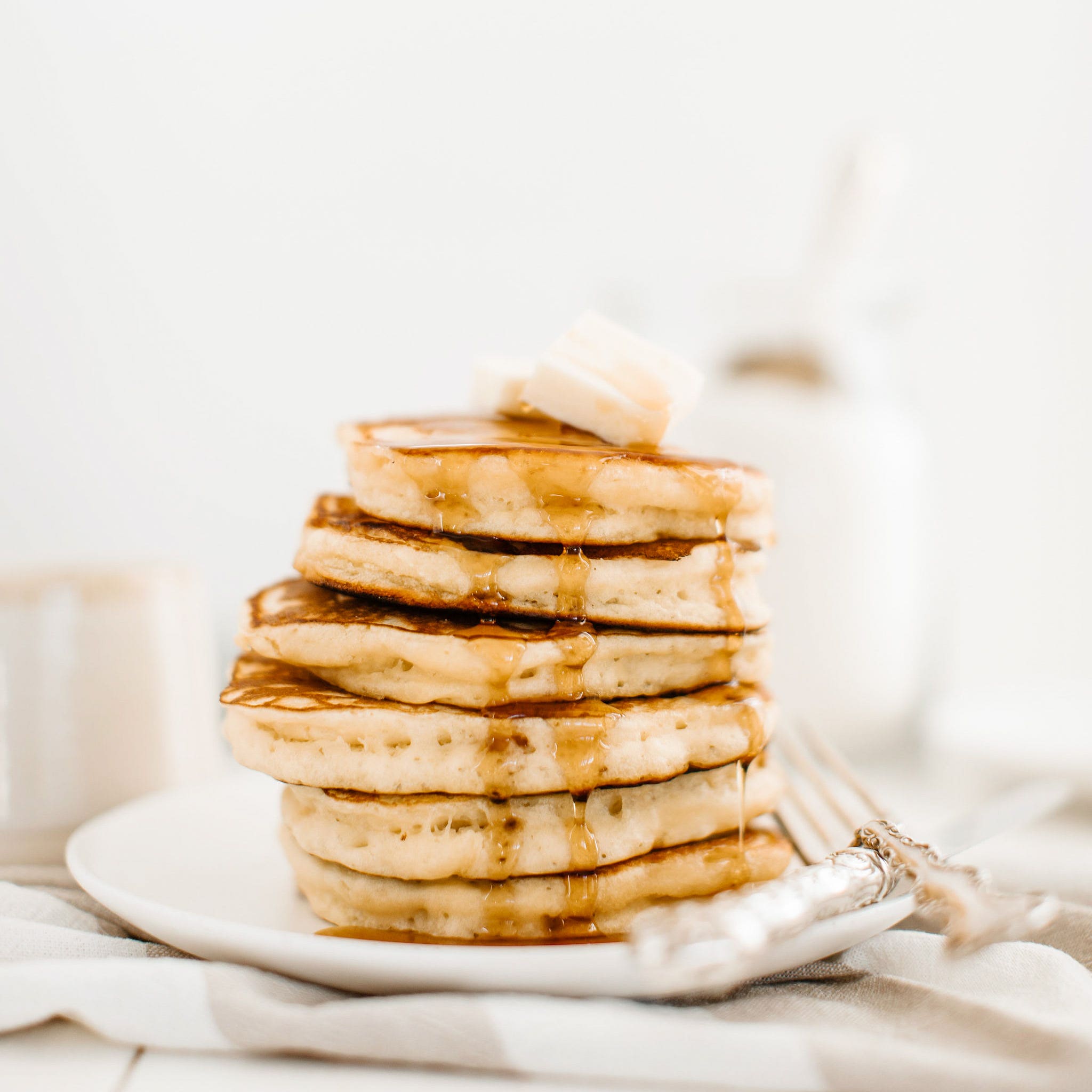 stack of pancakes drizzled in maple syrup