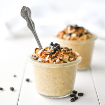 cafe au lait overnight oats in a jar topped with peanut butter and coffee beaans