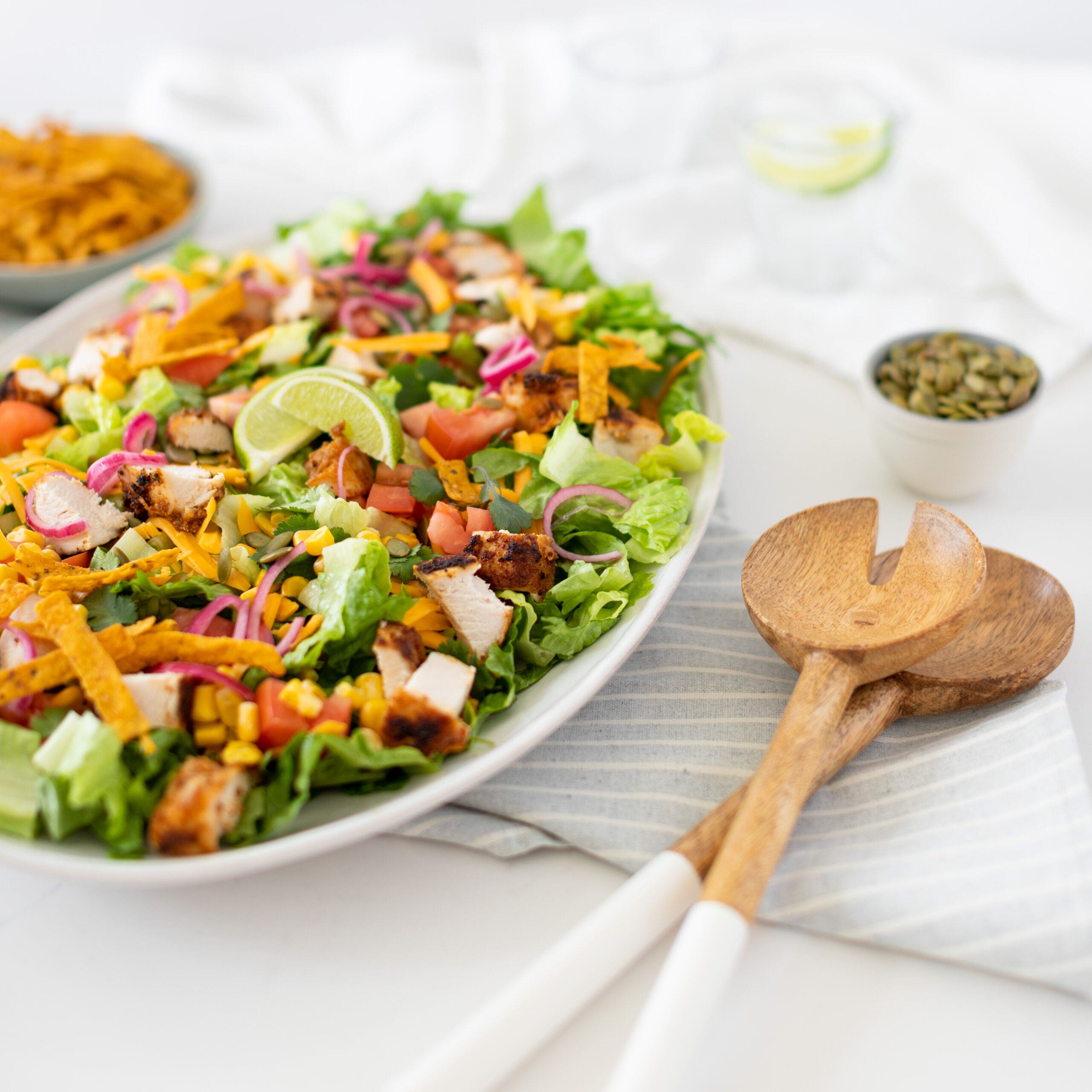 southwest chicken salad on a serving plate with serving tongs