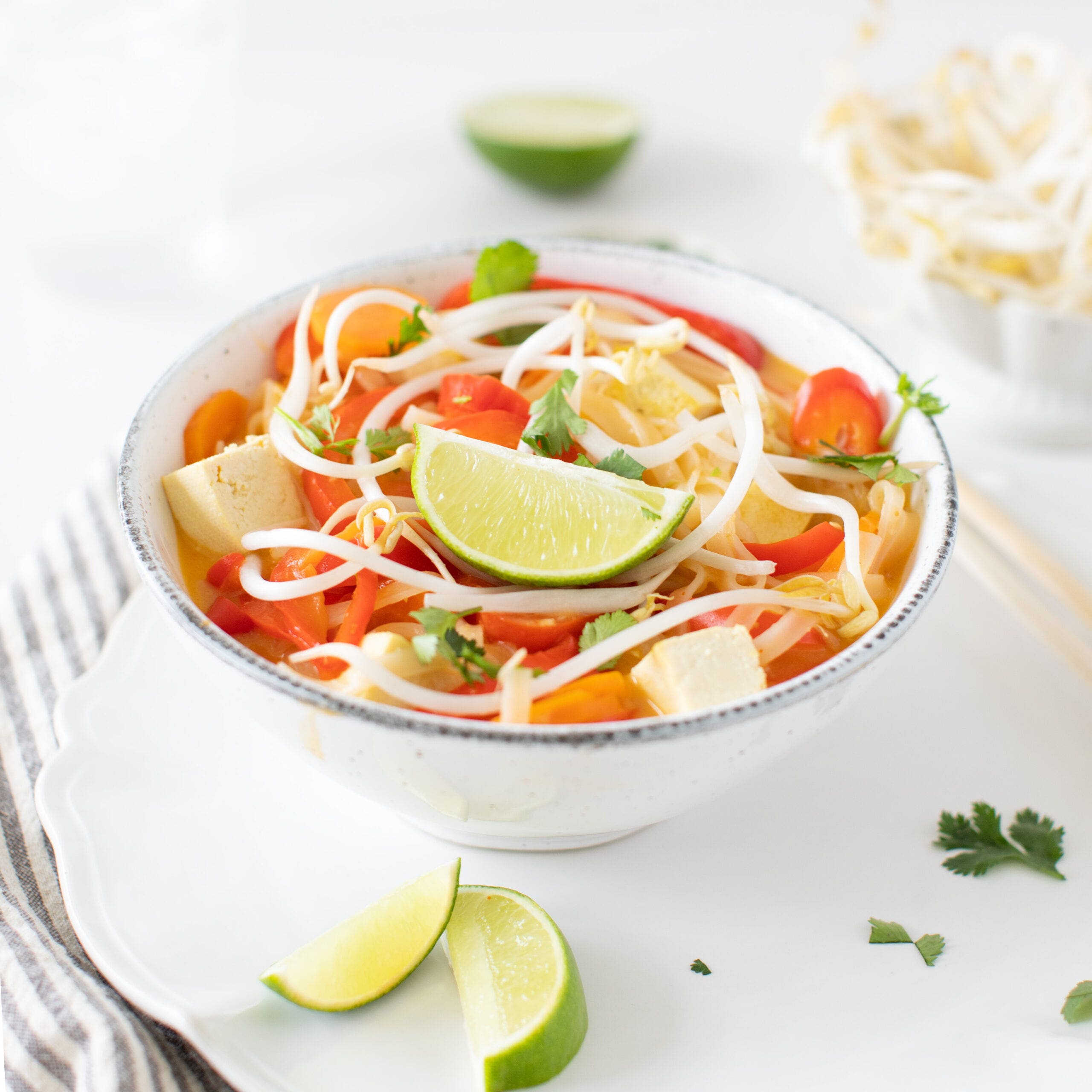 vegan coconut curry noodle bowl with limes