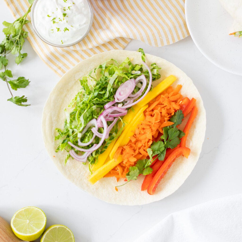 Fresh veggies and mango on tortilla with lime crema