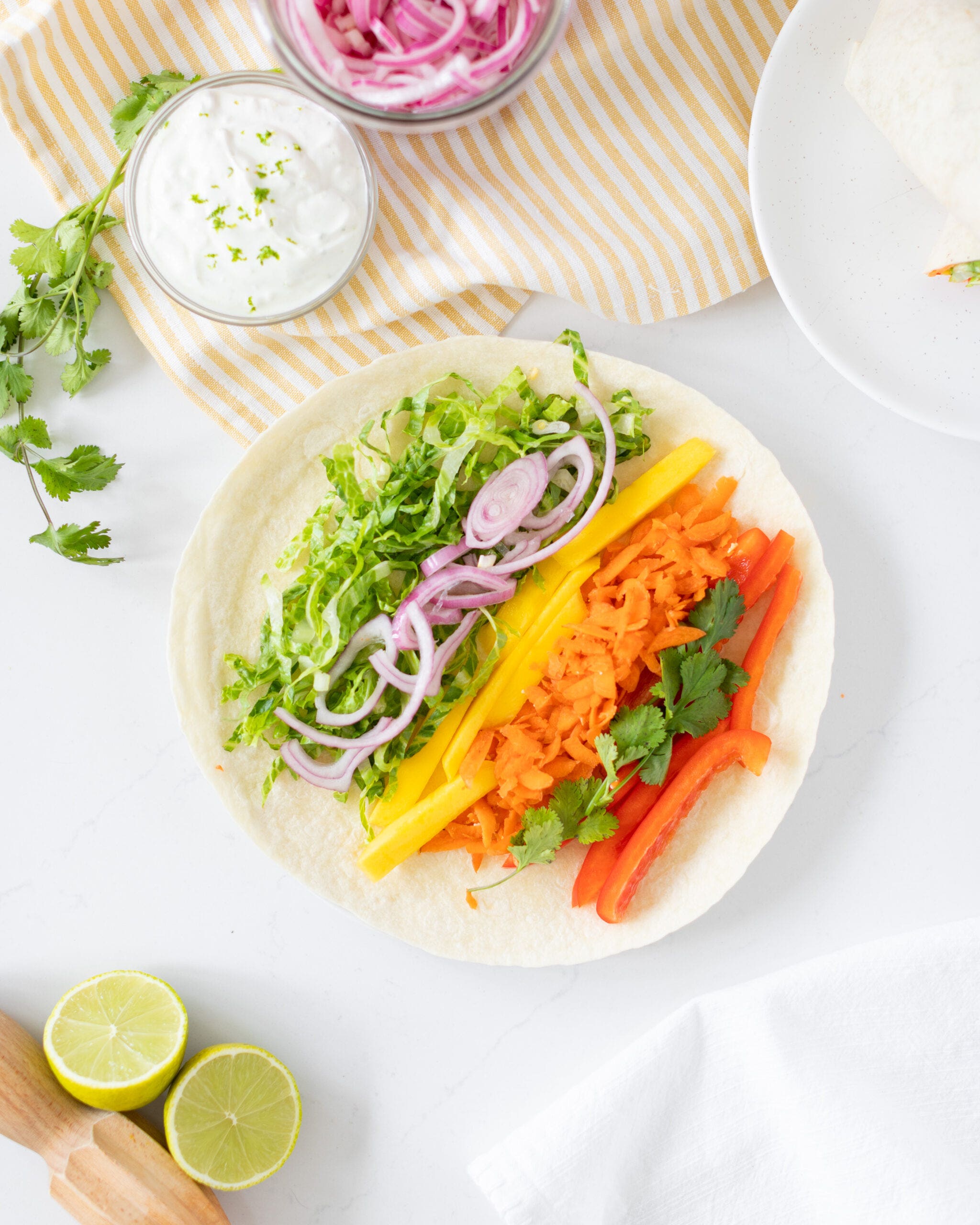 Fresh veggies and mango on tortilla with lime crema