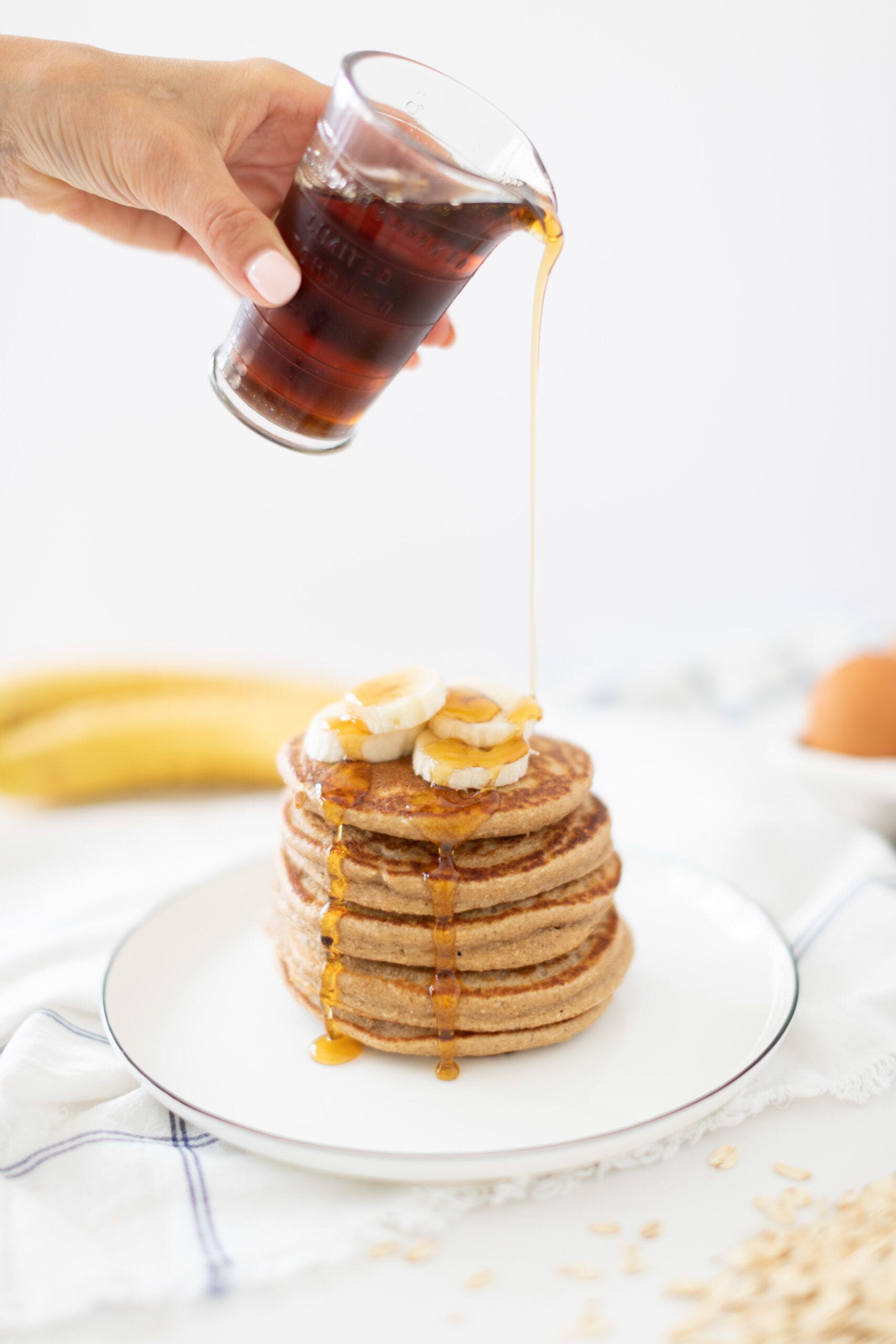 gluten free oat blender pancakes with syrup and bananas