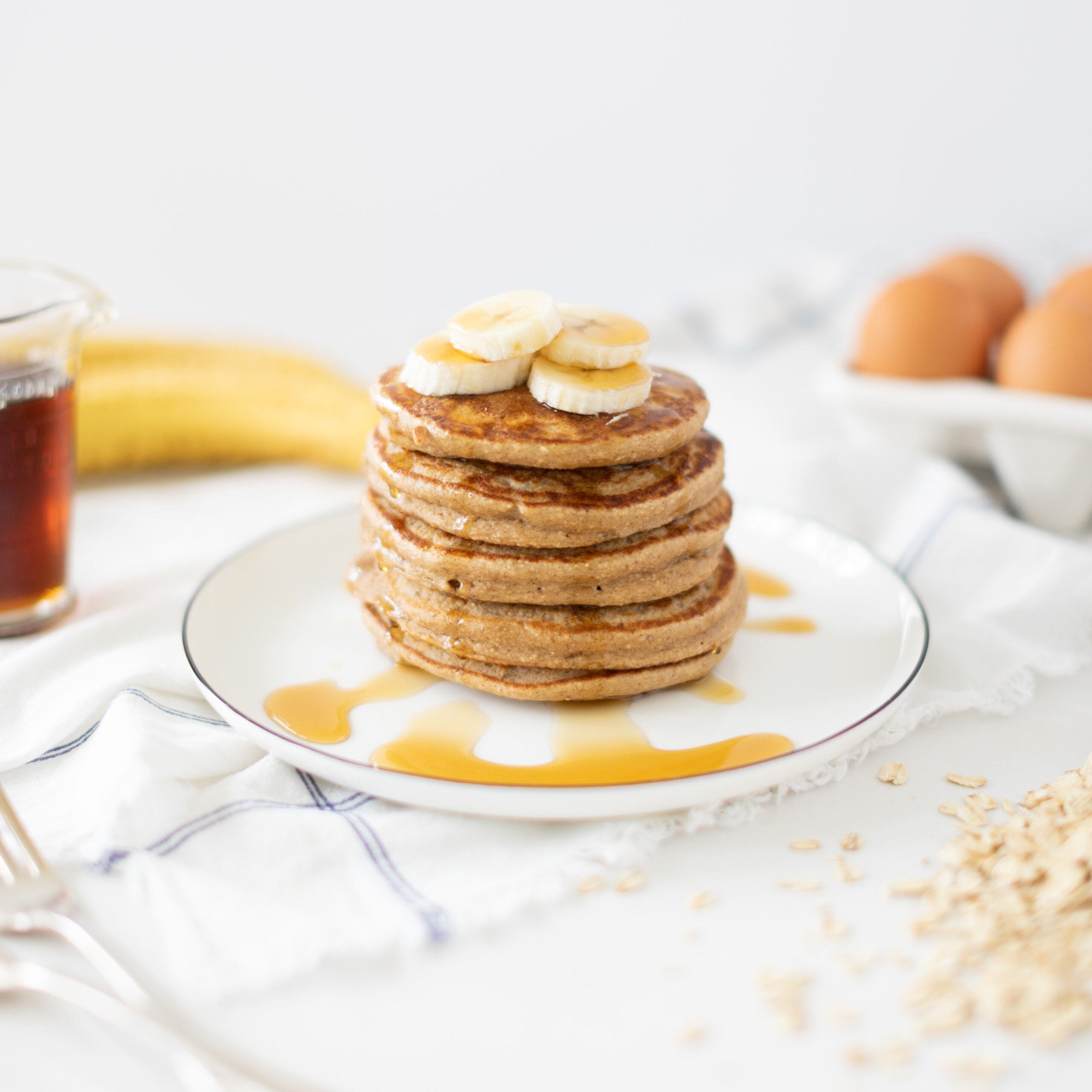 stack of pancakes drizzled in maple syrup