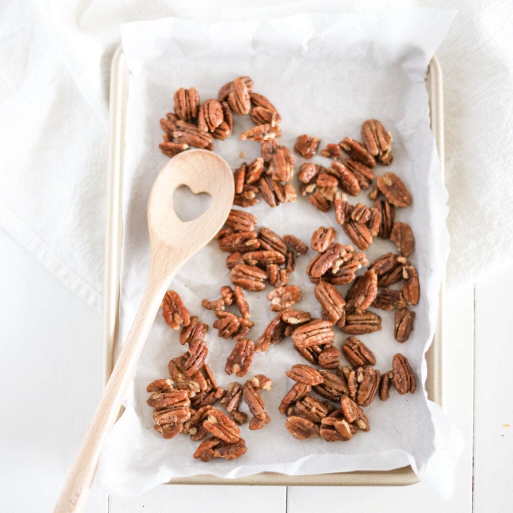 A cookie sheet filled with homemade sweet and spicy pecans.