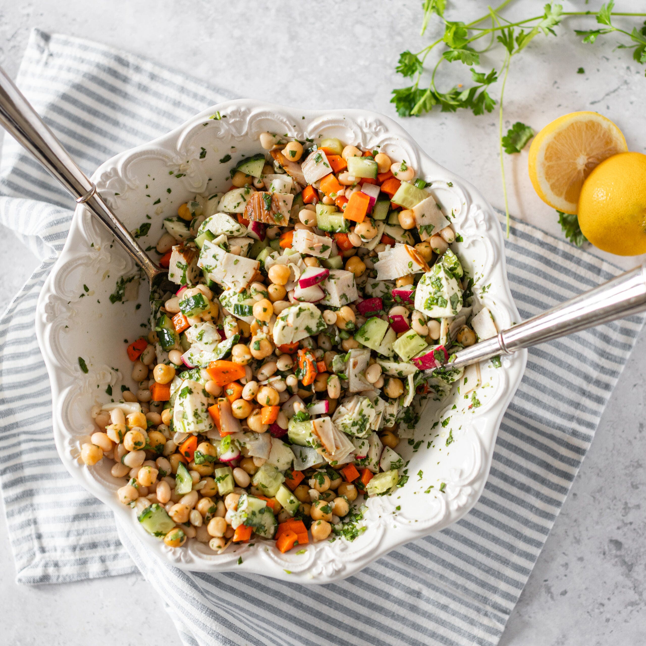 chickpea and bean salad with chopped turkey and a green herb dressing, served in a white bowl