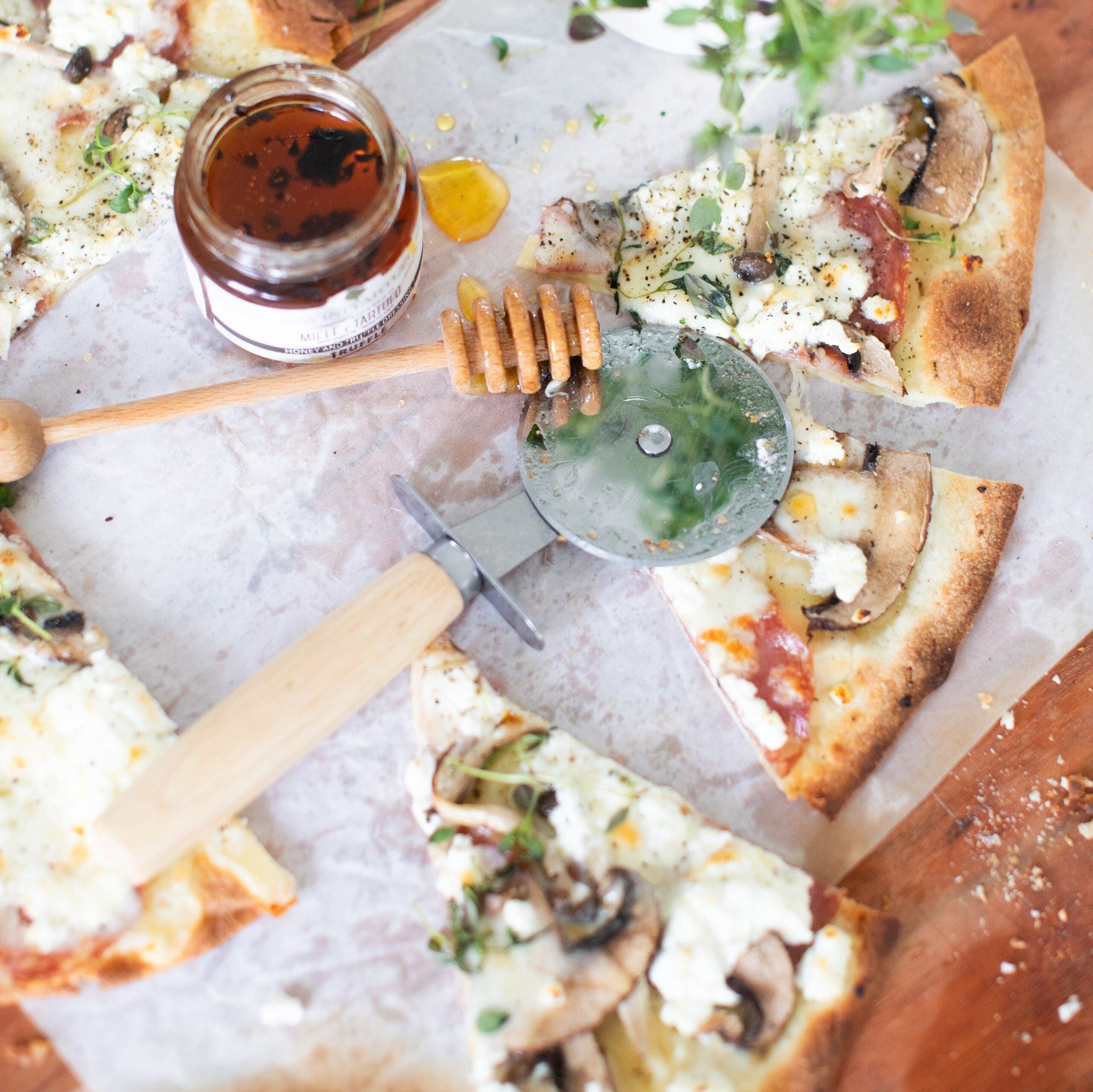 slices of pizza topped with mushrooms, goat cheese and honey