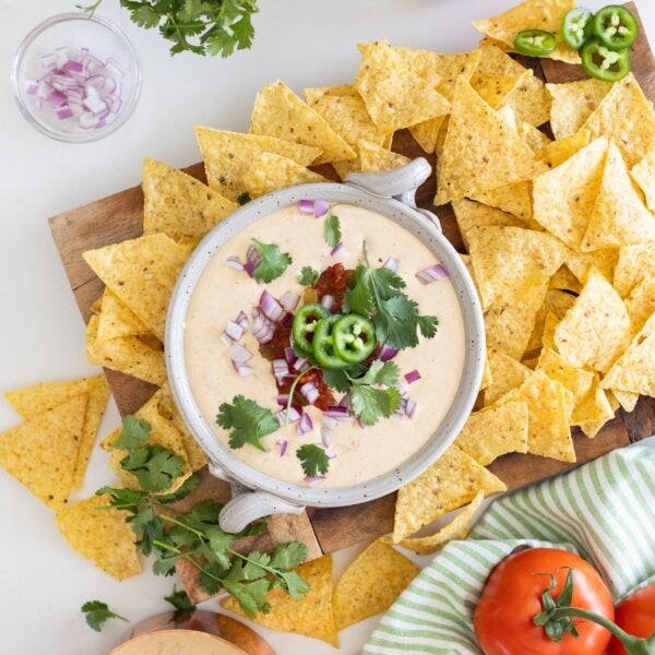 dip in a white dish surrounded by tortilla chips