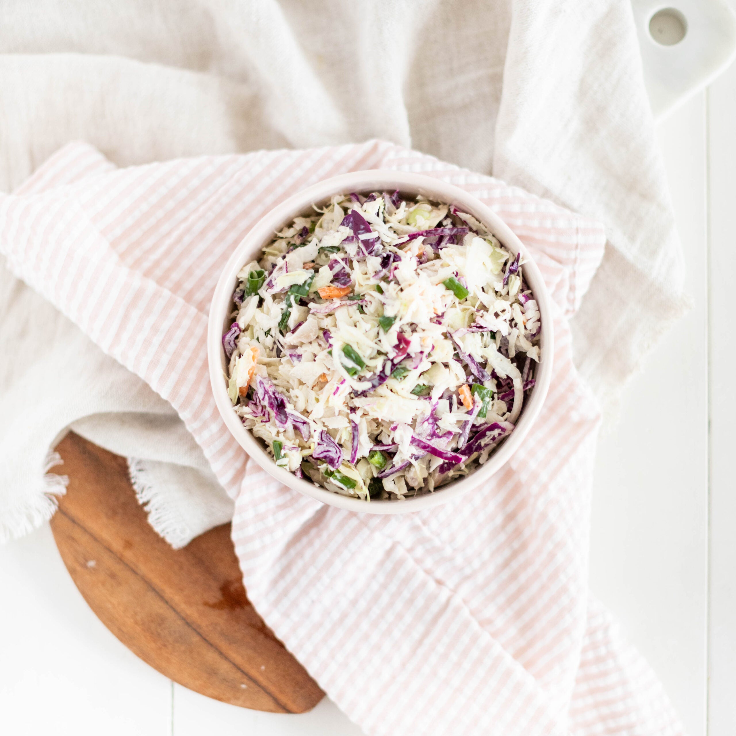 bowl of coleslaw sitting on a napkin